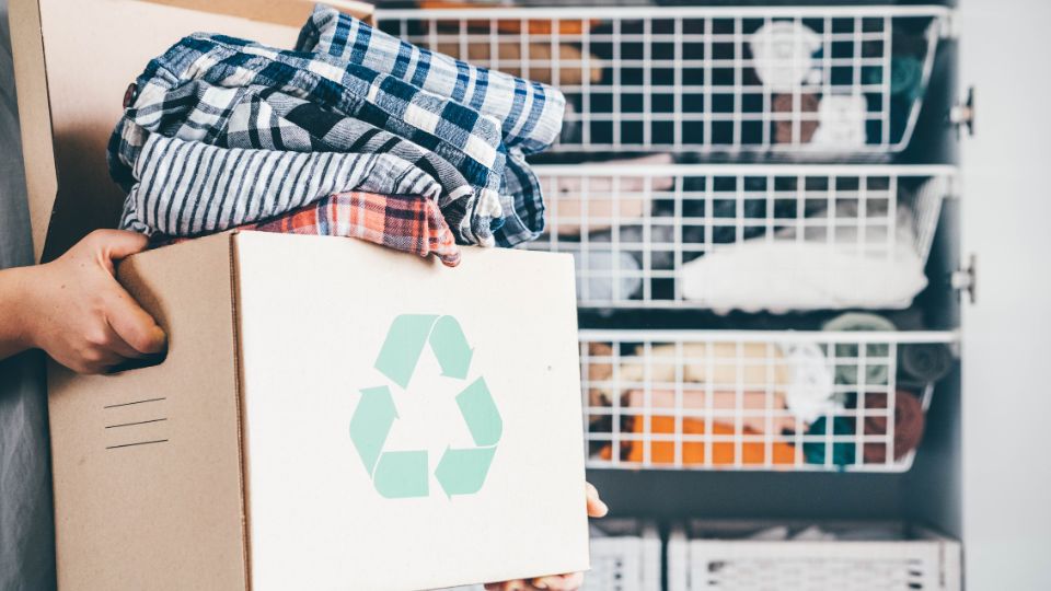 Clothing being recycled in a cardboard box.