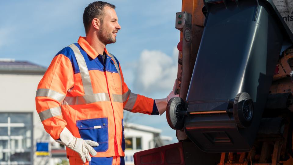 waste collector loading commercial waste onto a bin lorry
