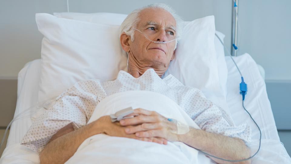 old person in a care home with IV and oxygen tank