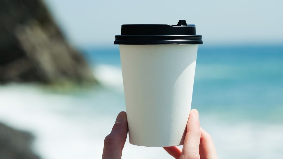 white disposable coffee cup with black plastic lid