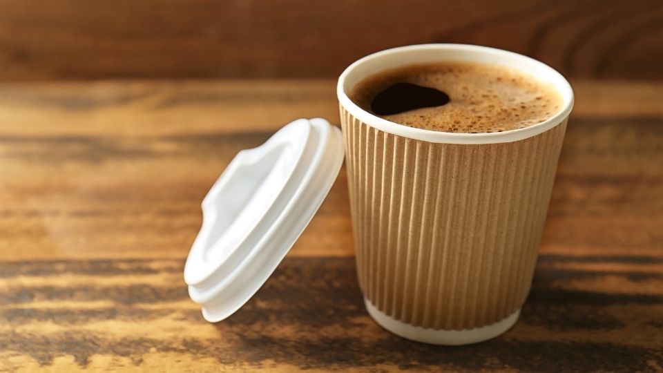 disposable coffee cup with cappuccino in