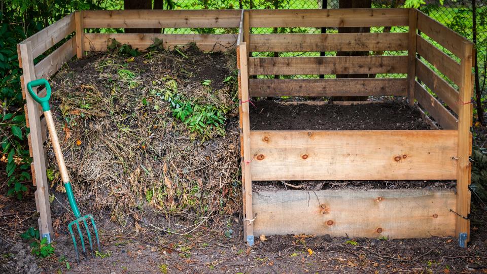 compost bin with a pitchfork and organic waste