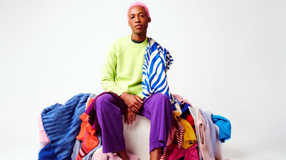 A man surrounded by lots of clothes