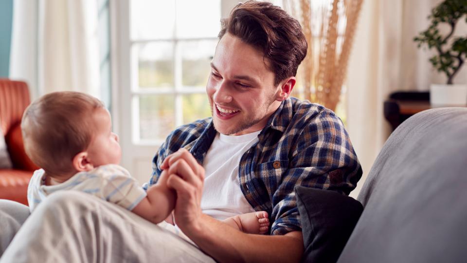 A young dad playing with his baby