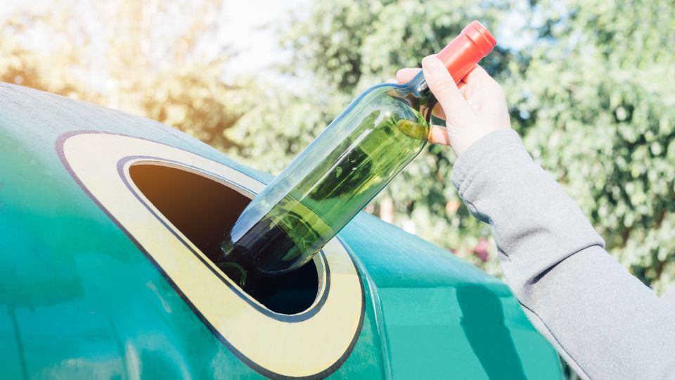 A photograph an old wine bottle being disposed of