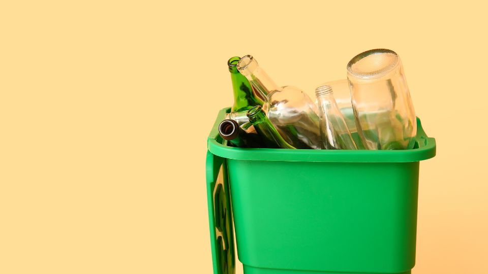 Glass waste in a green bin.