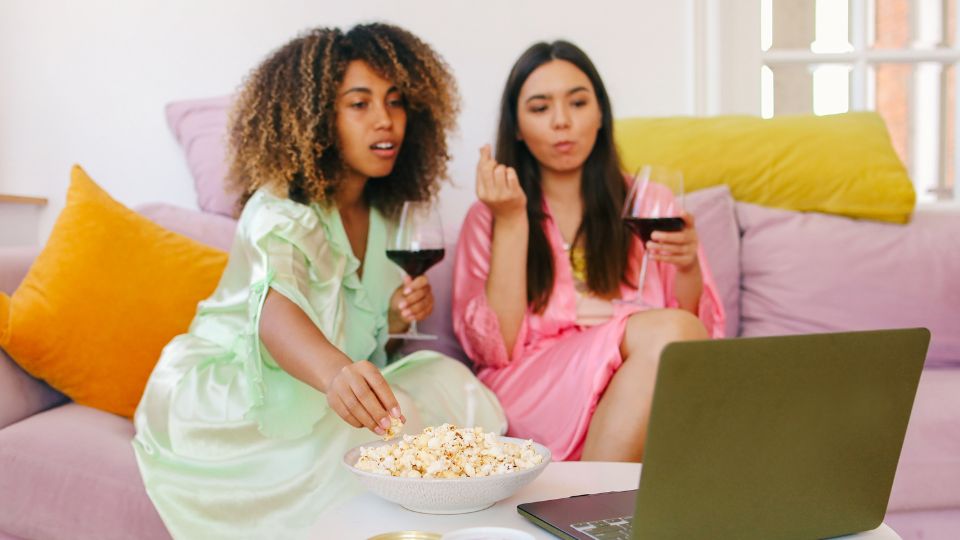 girls watching love island eating snacks and drinking wine