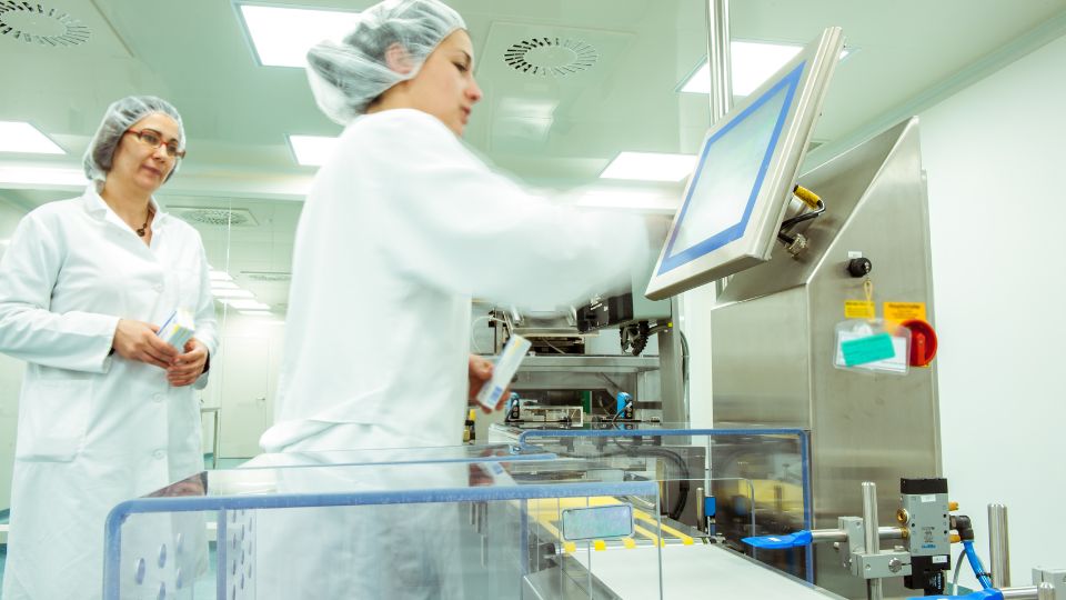 photograph of workers making medicine in a medical manufacturing facility