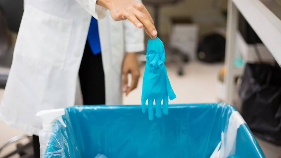 taking off contaminated gloves to prevent sharps injury