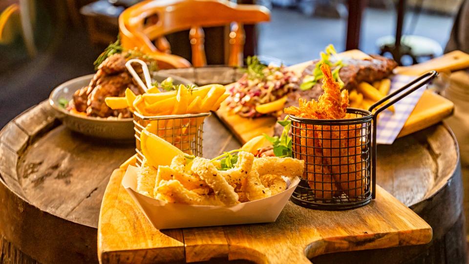 A picture of pub food including chips, fried shrimp and steak