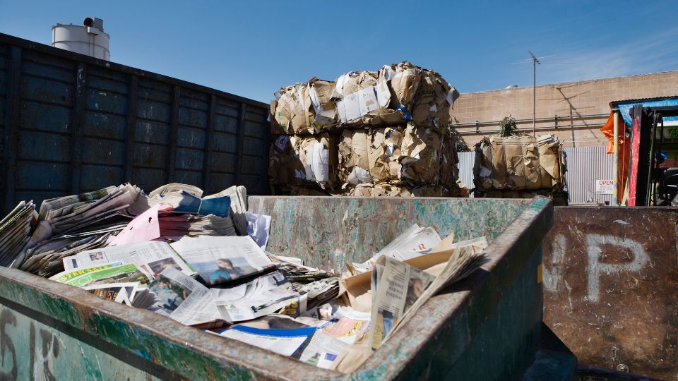 a recycling centre in the UK sorting newspapers