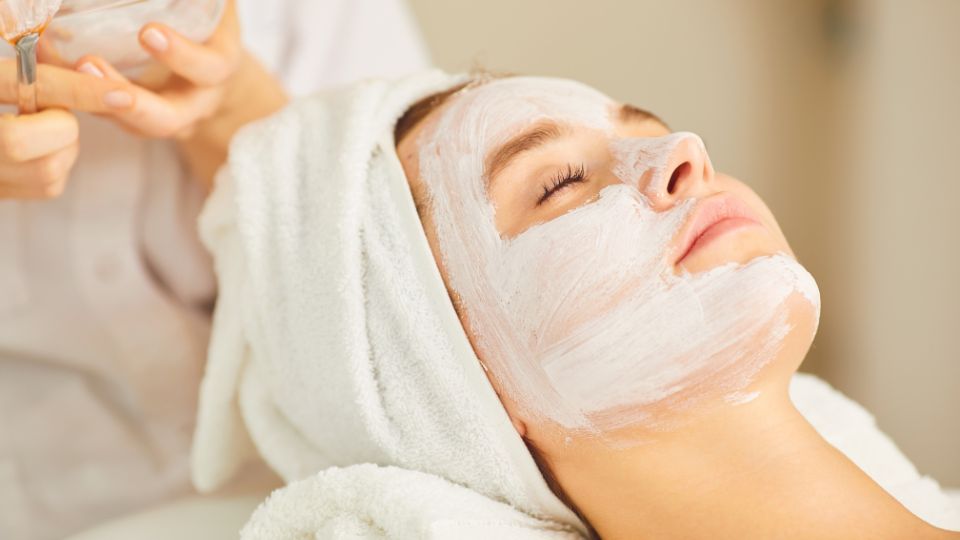 photo of a woman in a salon getting a face mask applied