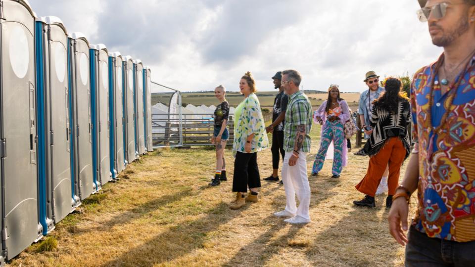 People queuing up for portaloos at a festival