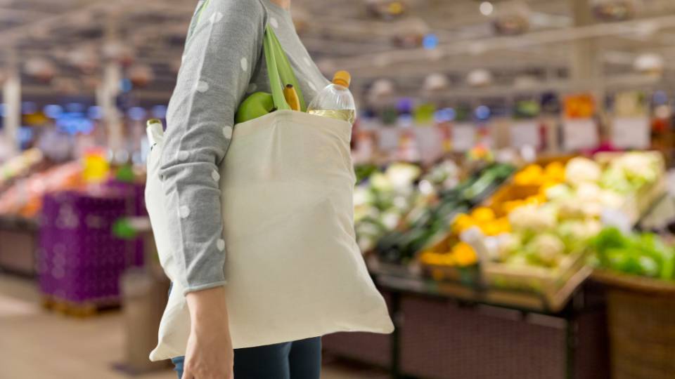 a tourist using a reusable bag to reduce plastic waste on summer holiday
