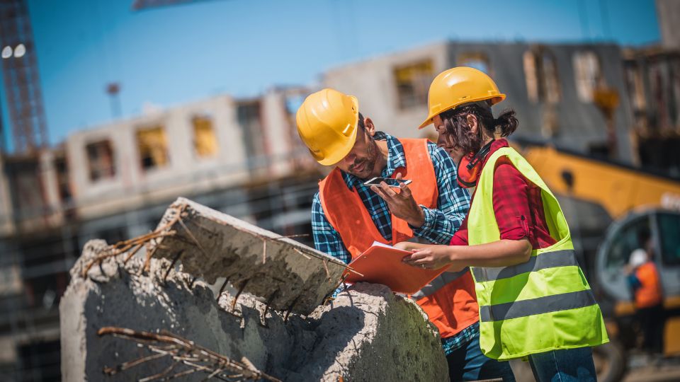 Construction workers managing waste at a site.