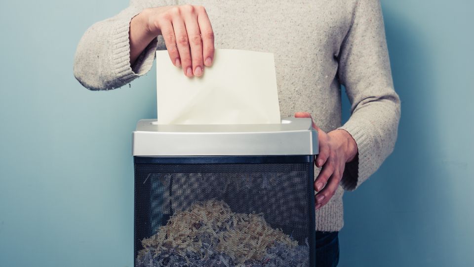 Person shredding confidential waste.
