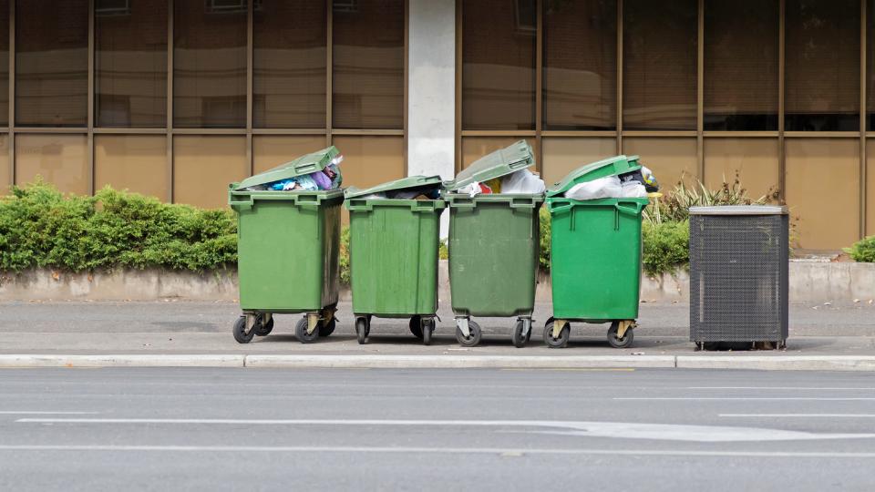 Four 660L wheelie bins on a street