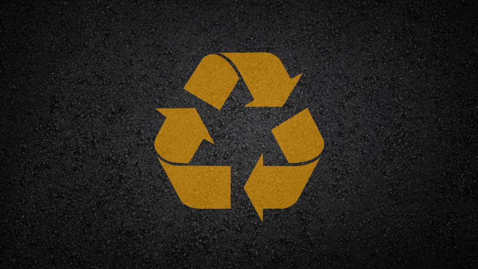 Yellow recycling sign on a tarmac road